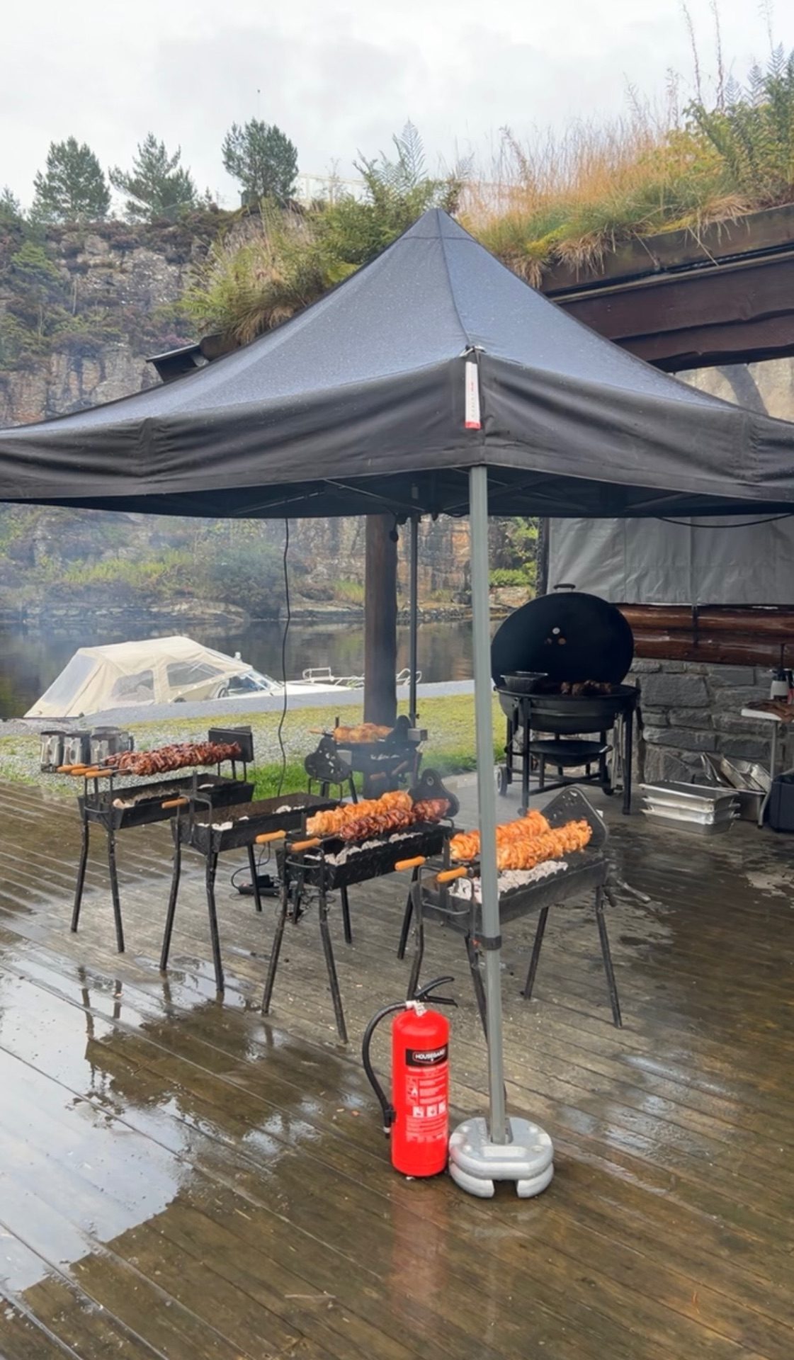 Grillene rigget opp under telt på brygga, med spyd og kull klare før servering
