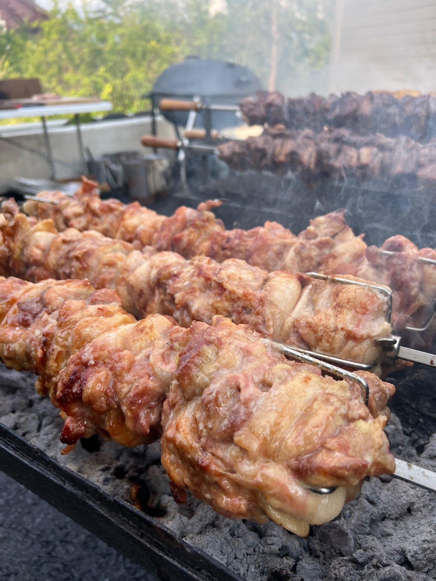 Flere souvlaspyd med svin og kylling i røyk over glødende kull