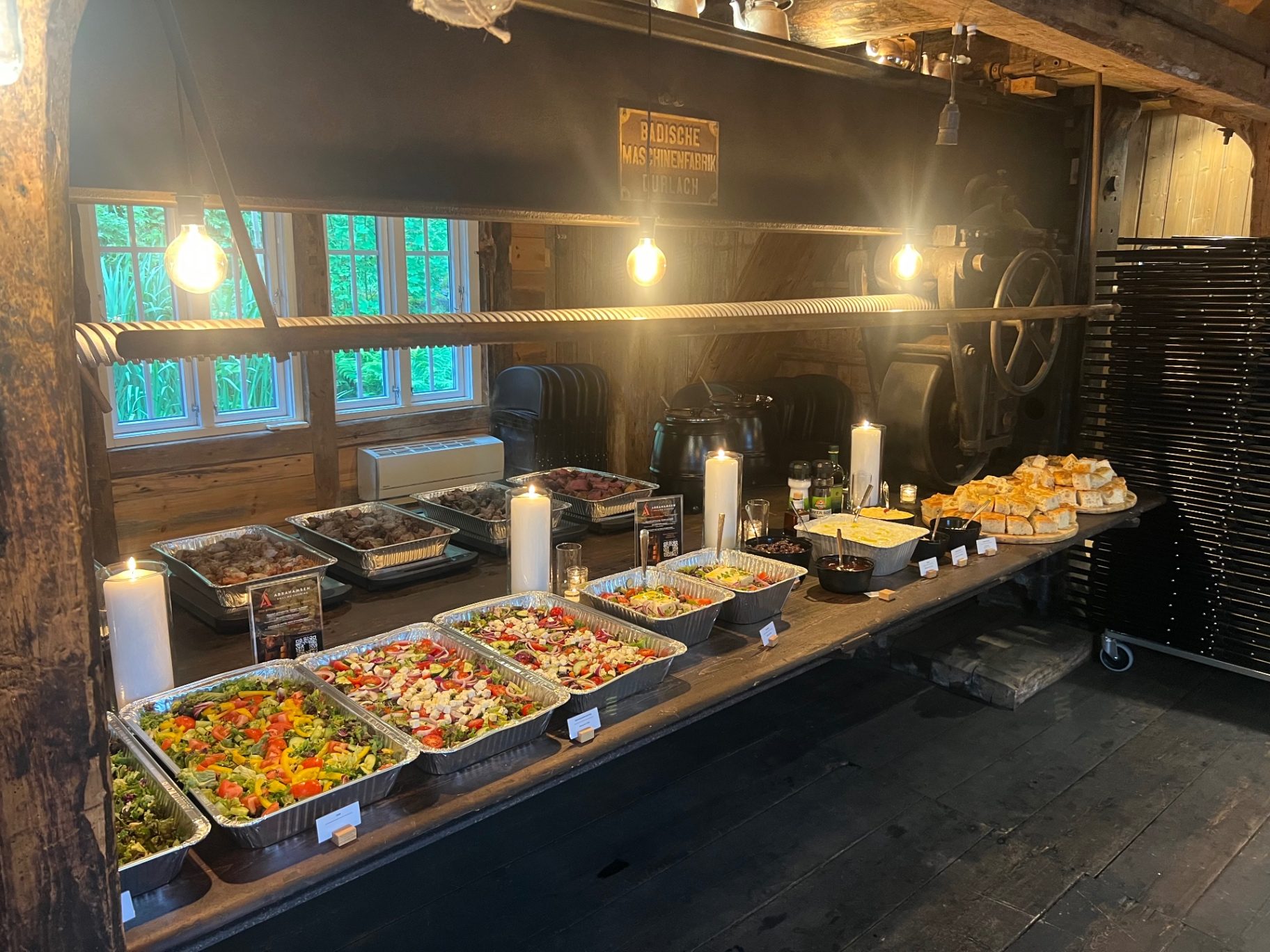 Grillbuffet med kjøtt, tilbehør og sauser på langt trebord